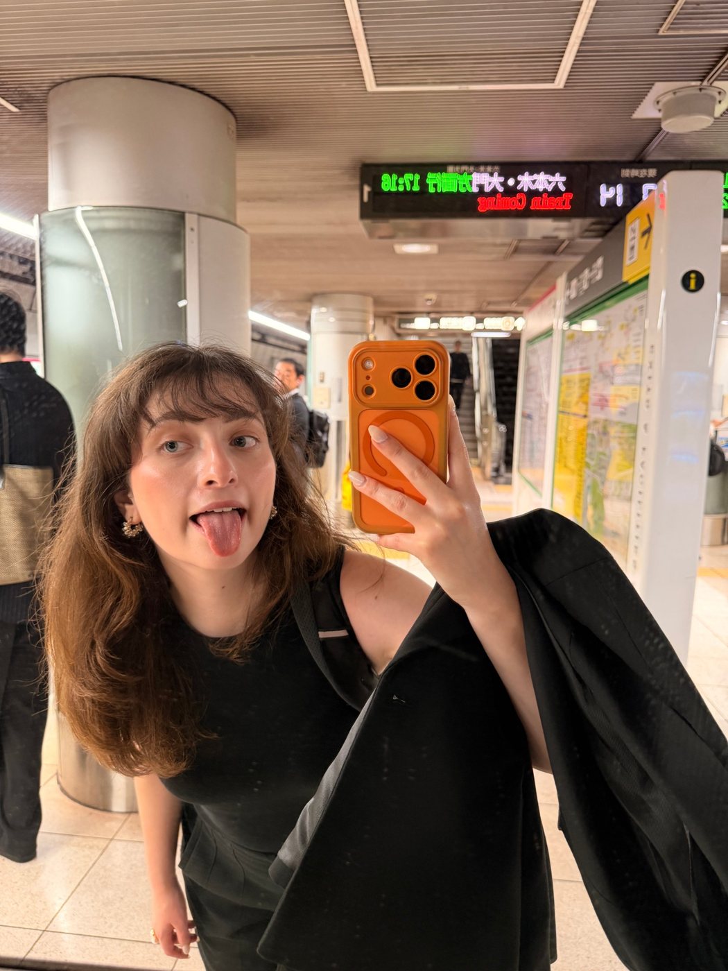 Nati tirando uma selfie divertida no espelho de uma estação de metrô